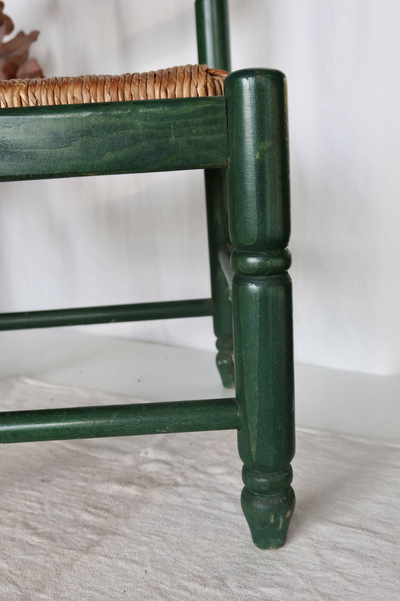 Vintage children's chair in green wood with a woven straw seat