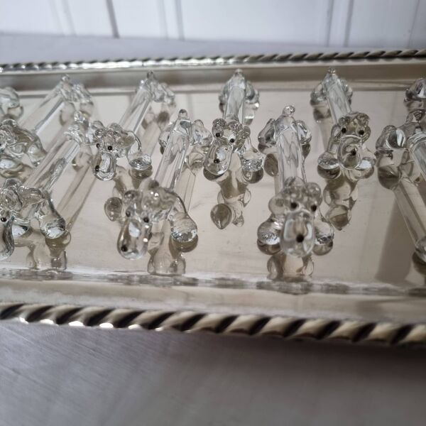 Un charmant coffret de 12 couteaux en verre moulé repose en forme de chien