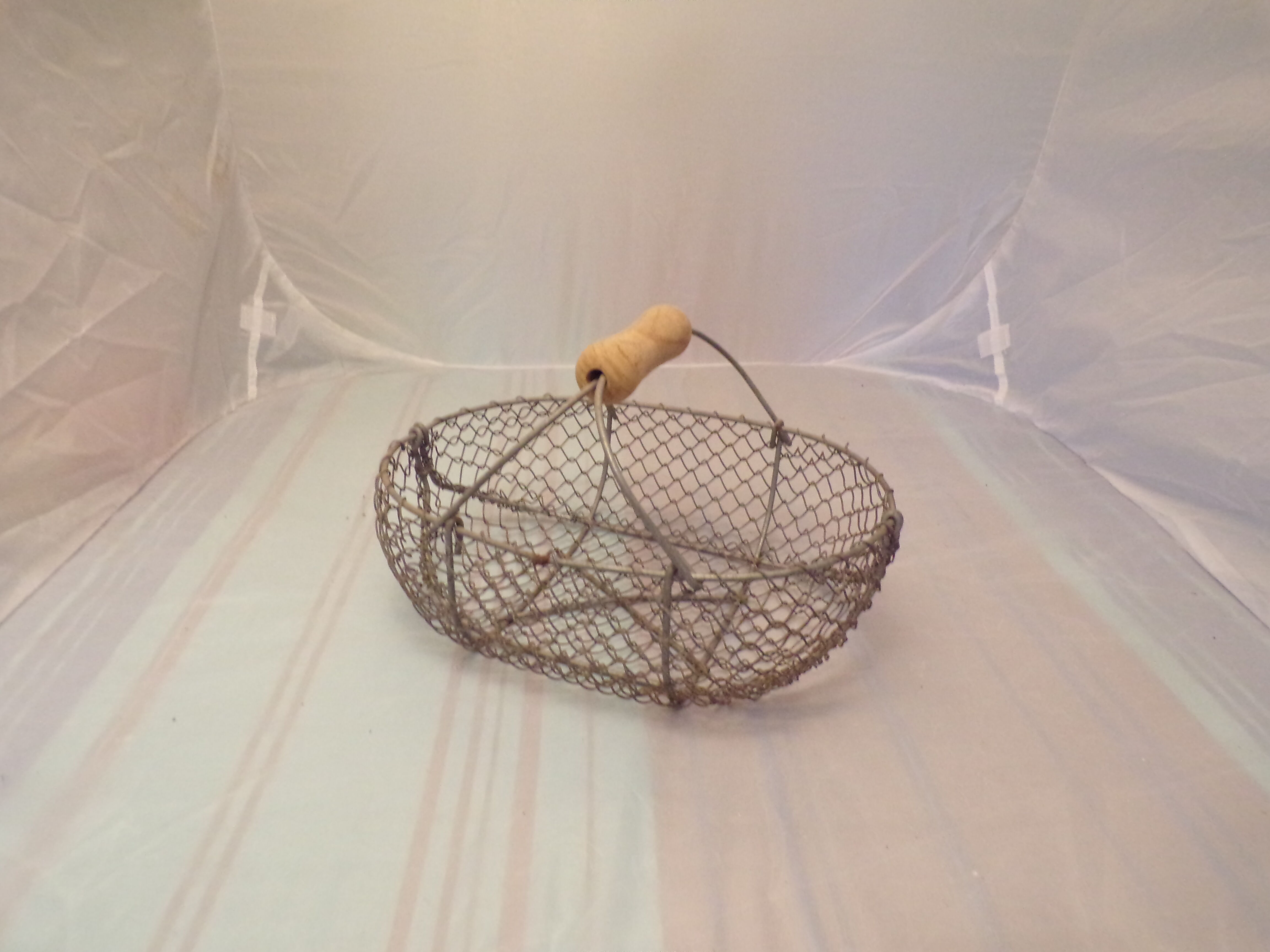 Basket has former apples in metal and wire mesh