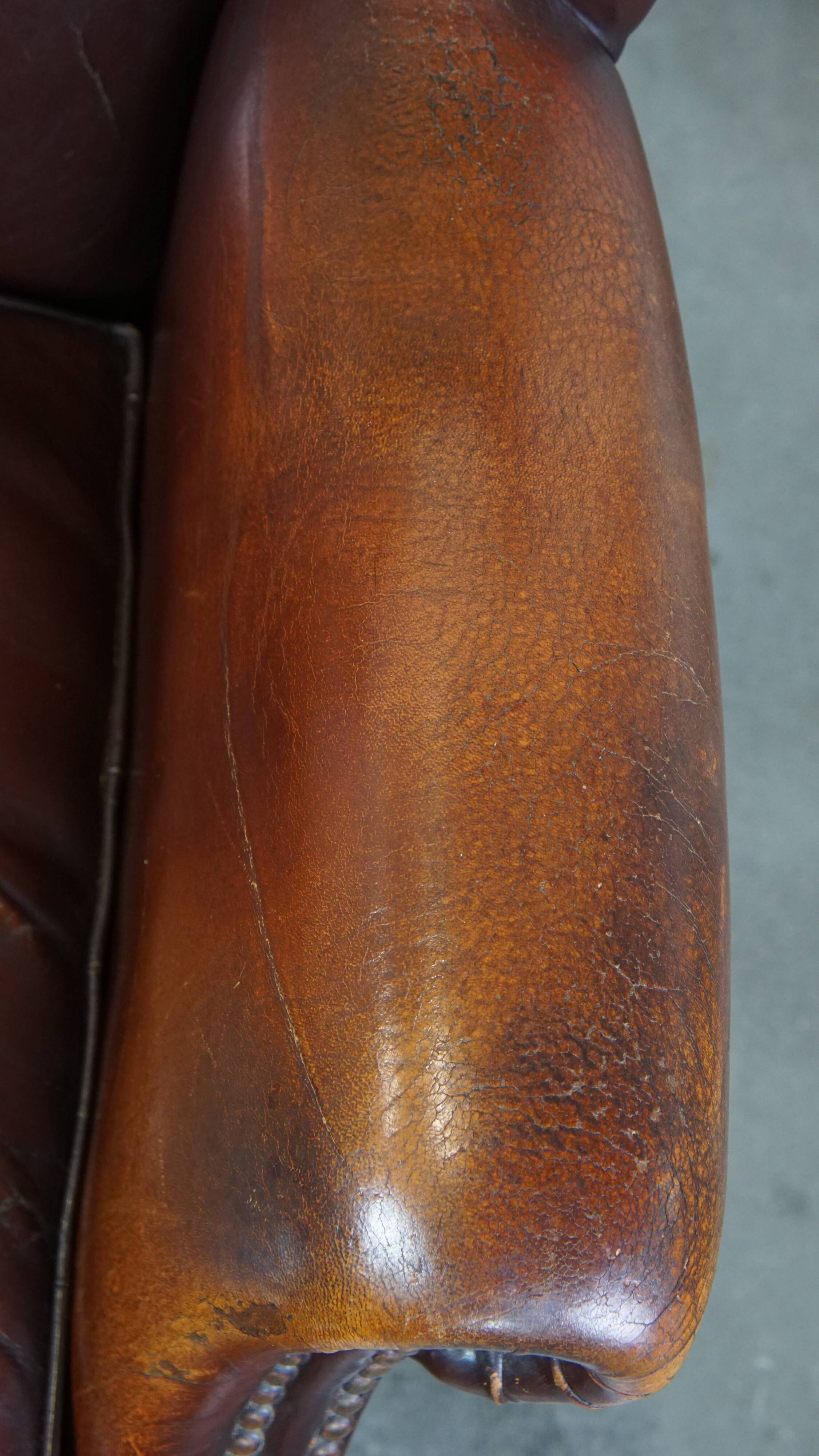 Dark English style sheepskin wingback chair with character and patina