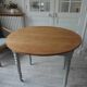Walnut table with raised flaps, base on verdigris casters.