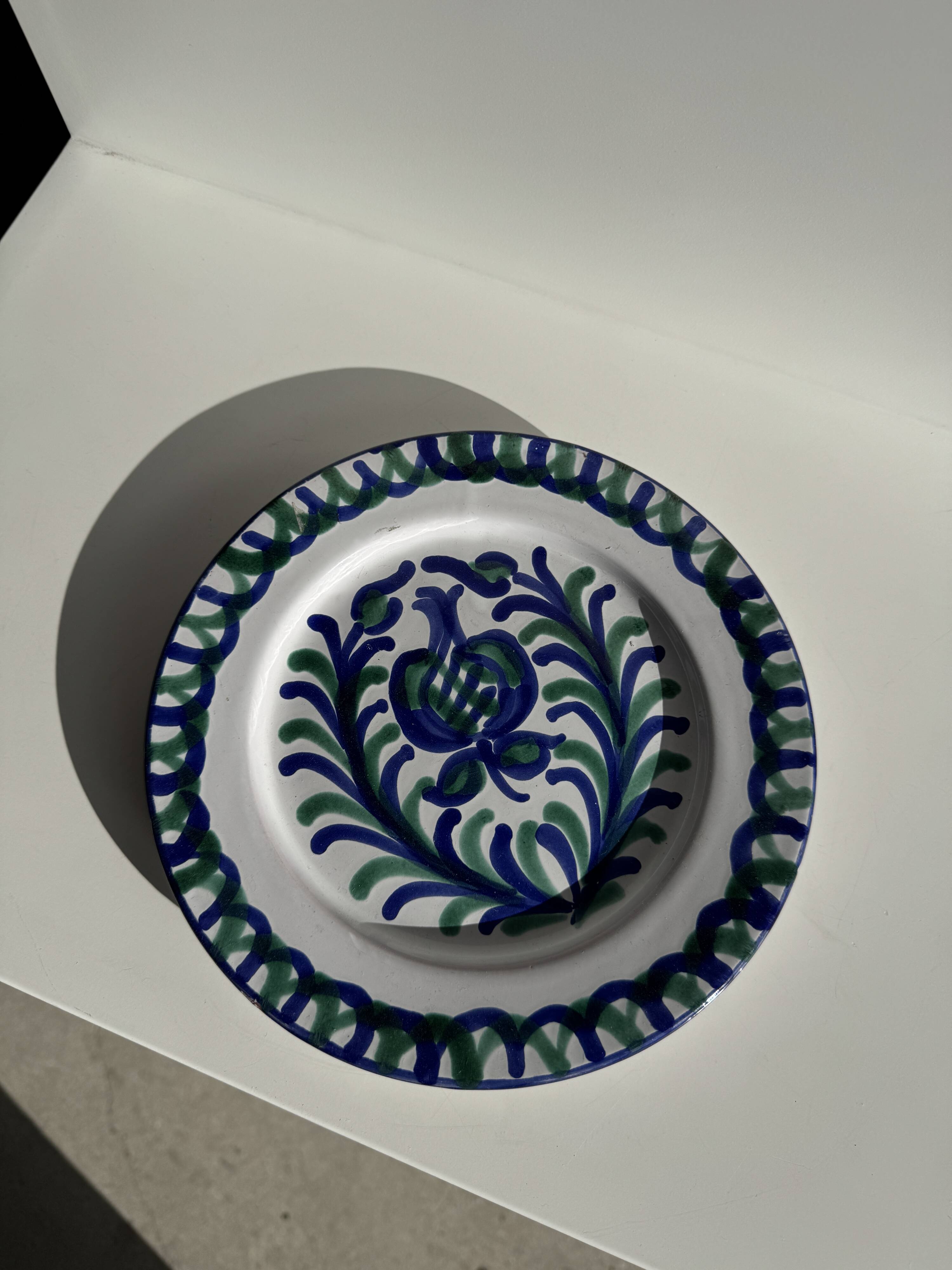 Artesania Alvarez Spanish plate in terracotta with blue plant motif.