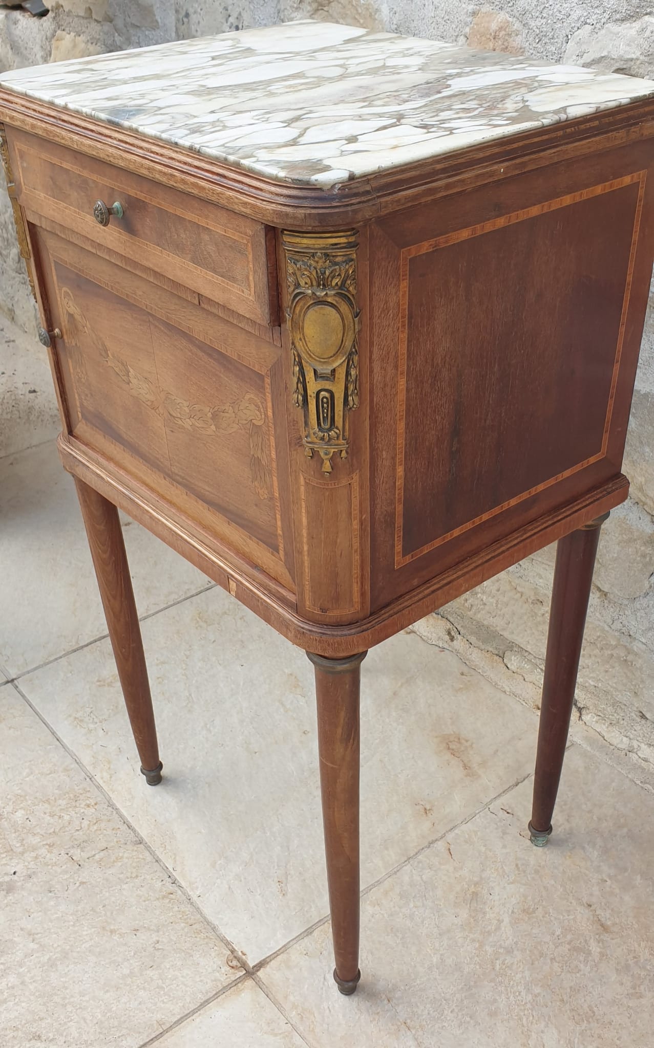 Old wooden bedside table on marble top