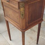Old wooden bedside table on marble top