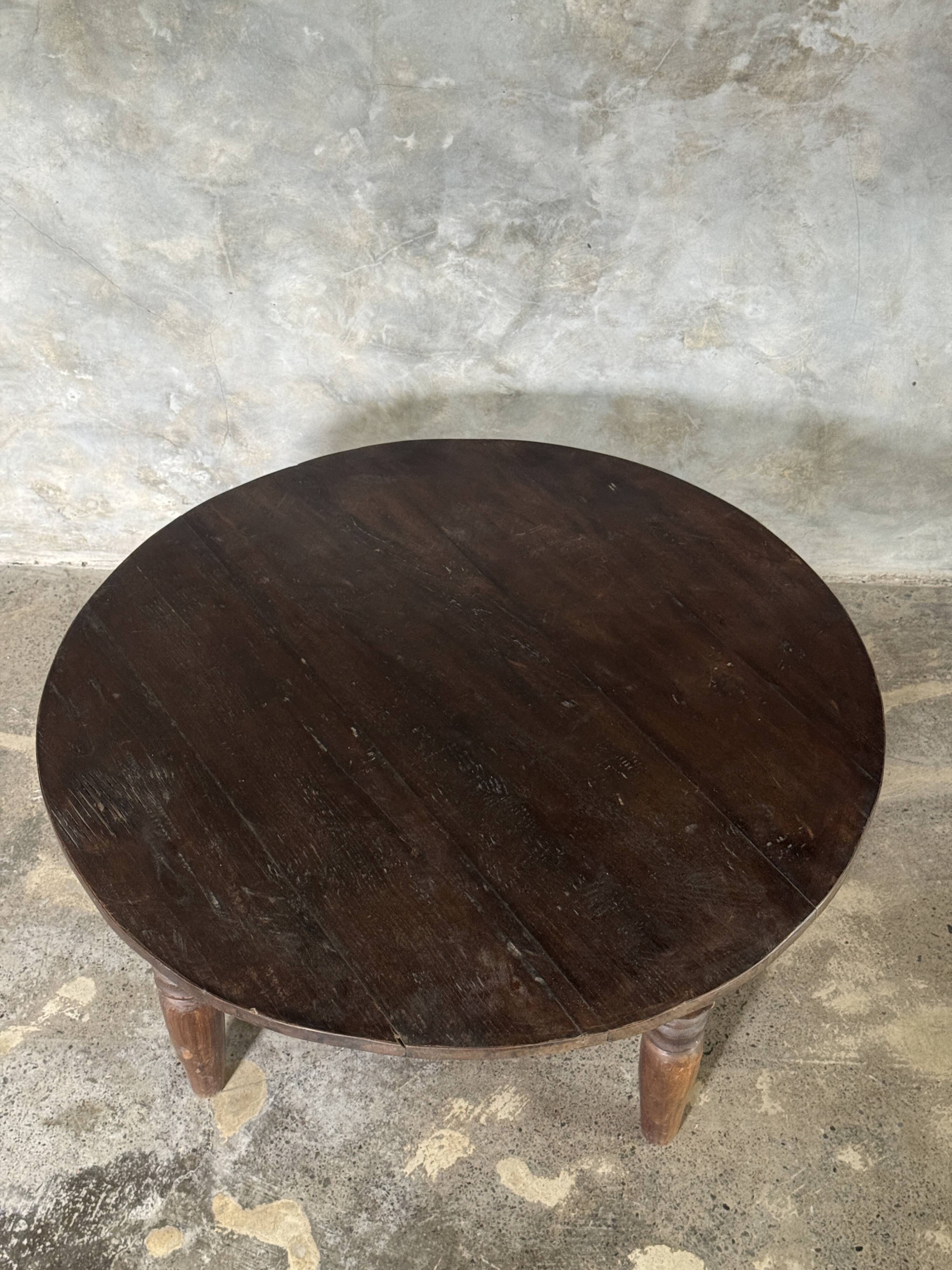 Coffee table, round antique Indonesian teak table with straight legs.