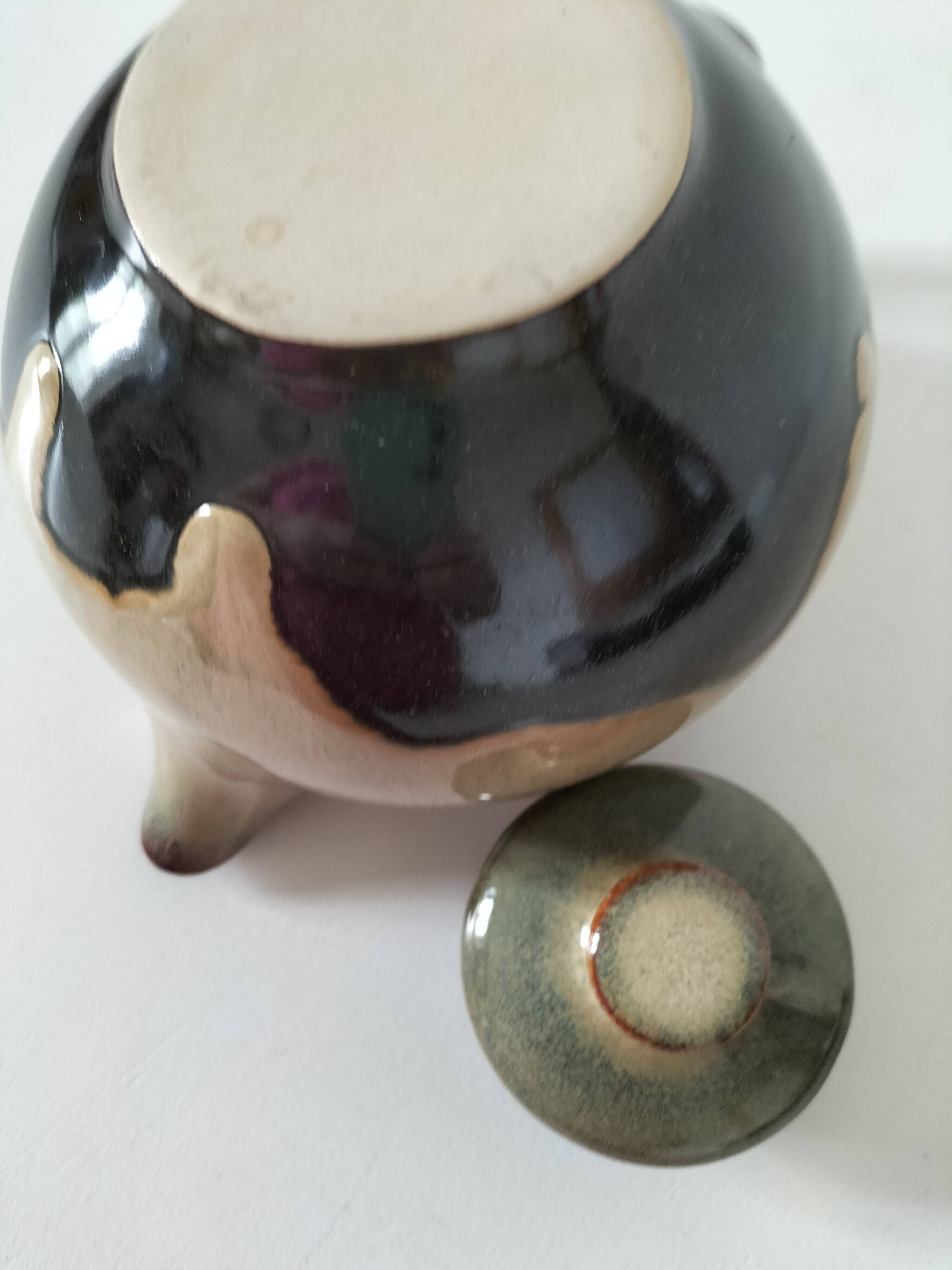 Vintage ceramic teapot with a flame design.