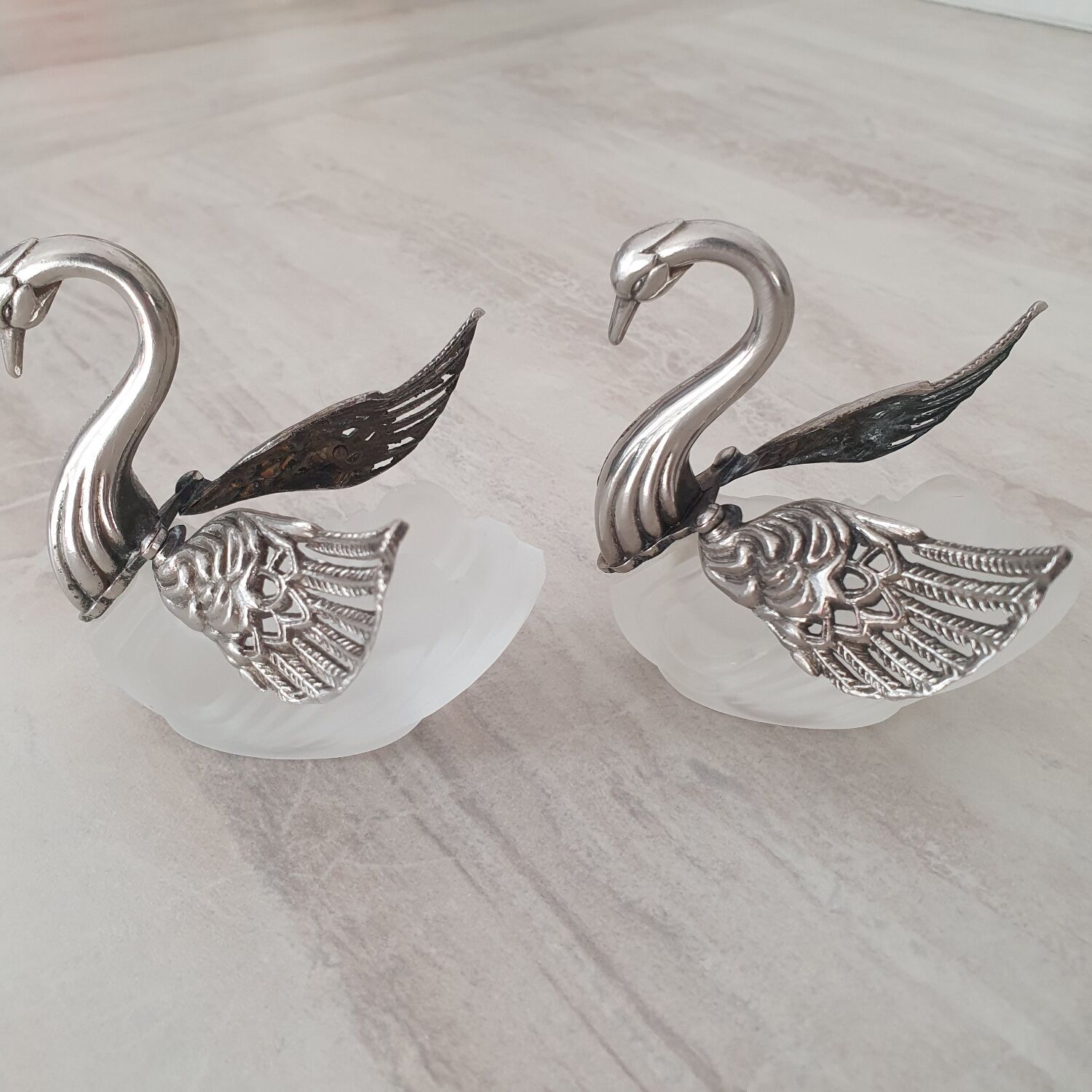 Two frosted glass swan salt cellars with silver plating.