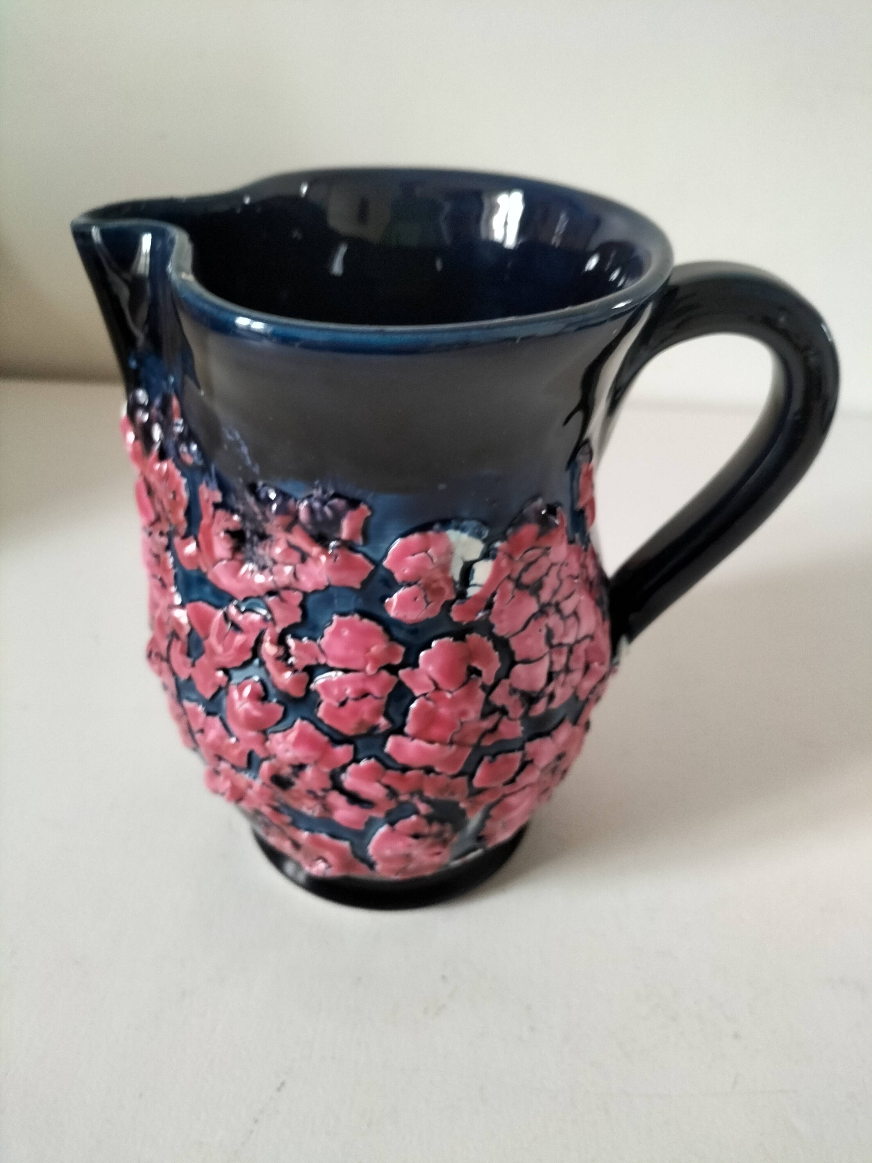 Vintage pitcher in midnight blue glazed ceramic with bright pink relief