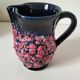 Vintage pitcher in midnight blue glazed ceramic with bright pink relief