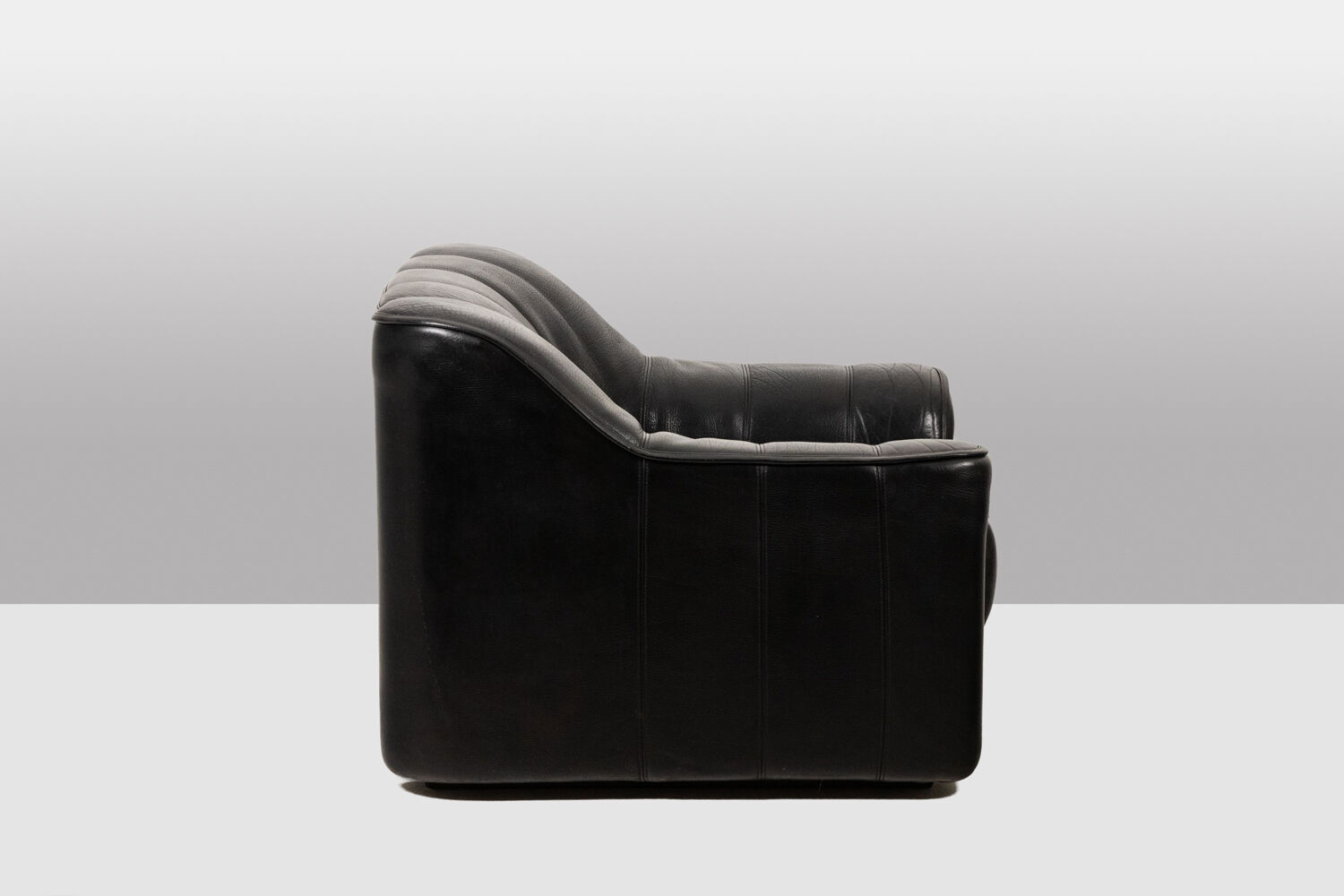 Maison De Sede. Armchair and its ottoman in black leather. 1970s.