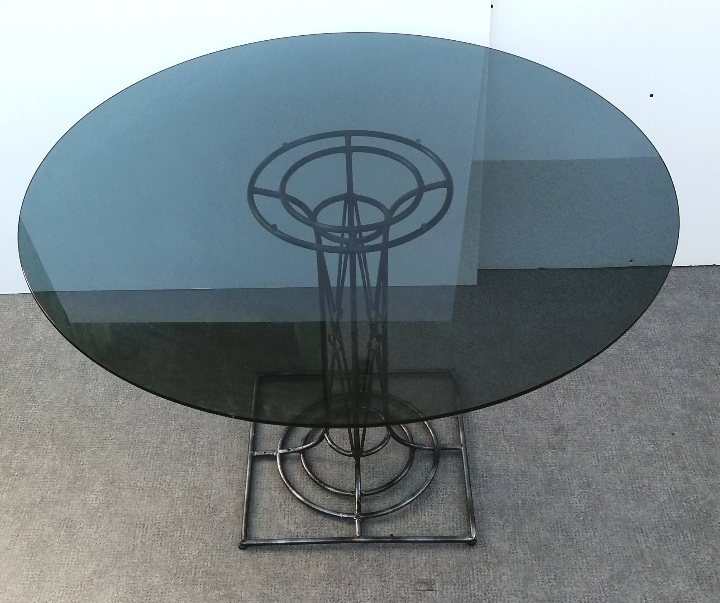 Wrought iron dining table with its round smoked glass top, vintage 1980