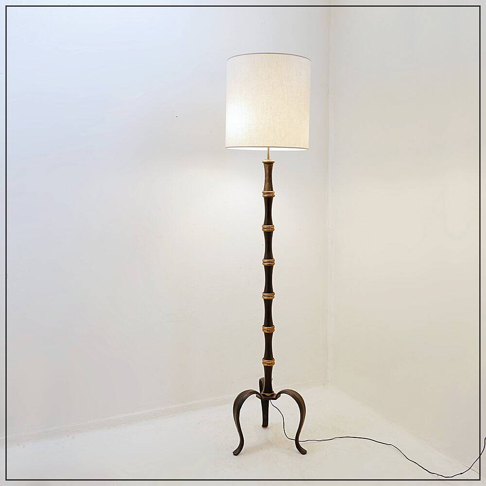 Tripod floor lamp in wrought iron and brass with bamboo-style base.