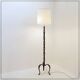 Tripod floor lamp in wrought iron and brass with bamboo-style base.