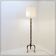 Tripod floor lamp in wrought iron and brass with bamboo-style base.
