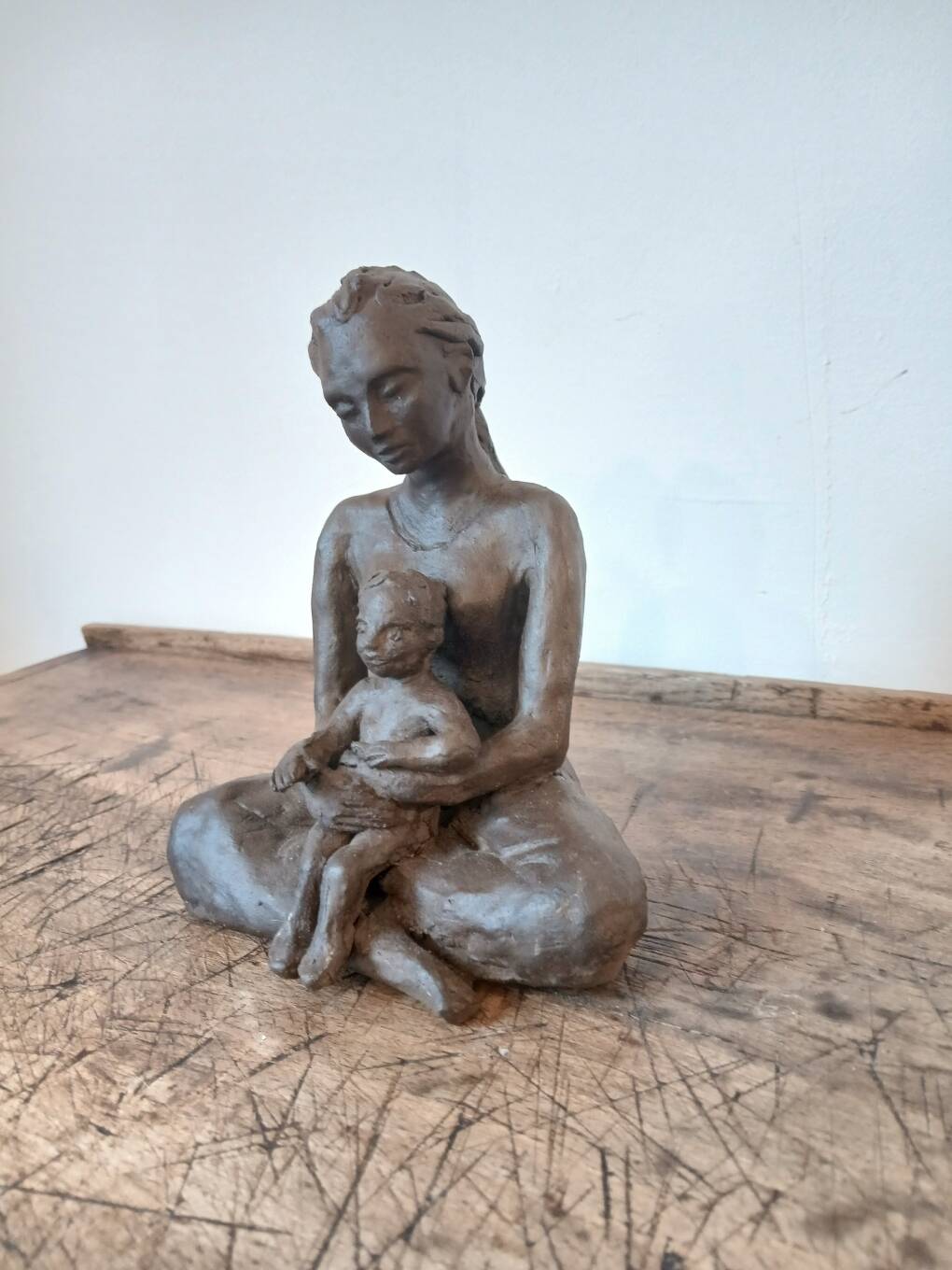 Terracotta statue of a woman with child, signed