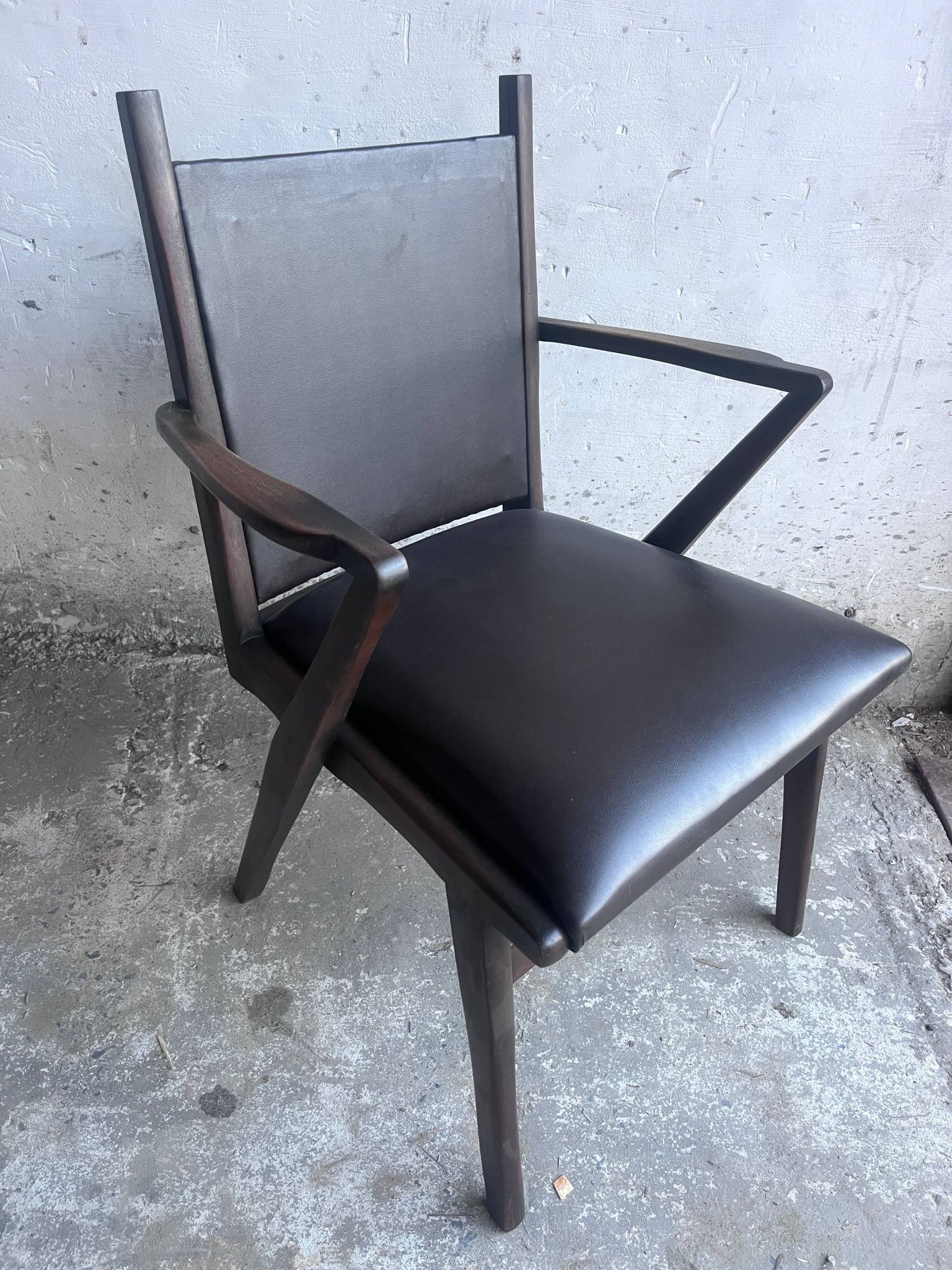 Pair of sculptural mid-century armchairs in dark wood and brown upholstery.