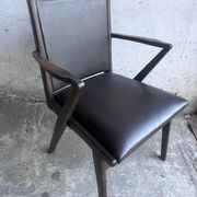 Pair of sculptural mid-century armchairs in dark wood and brown upholstery.