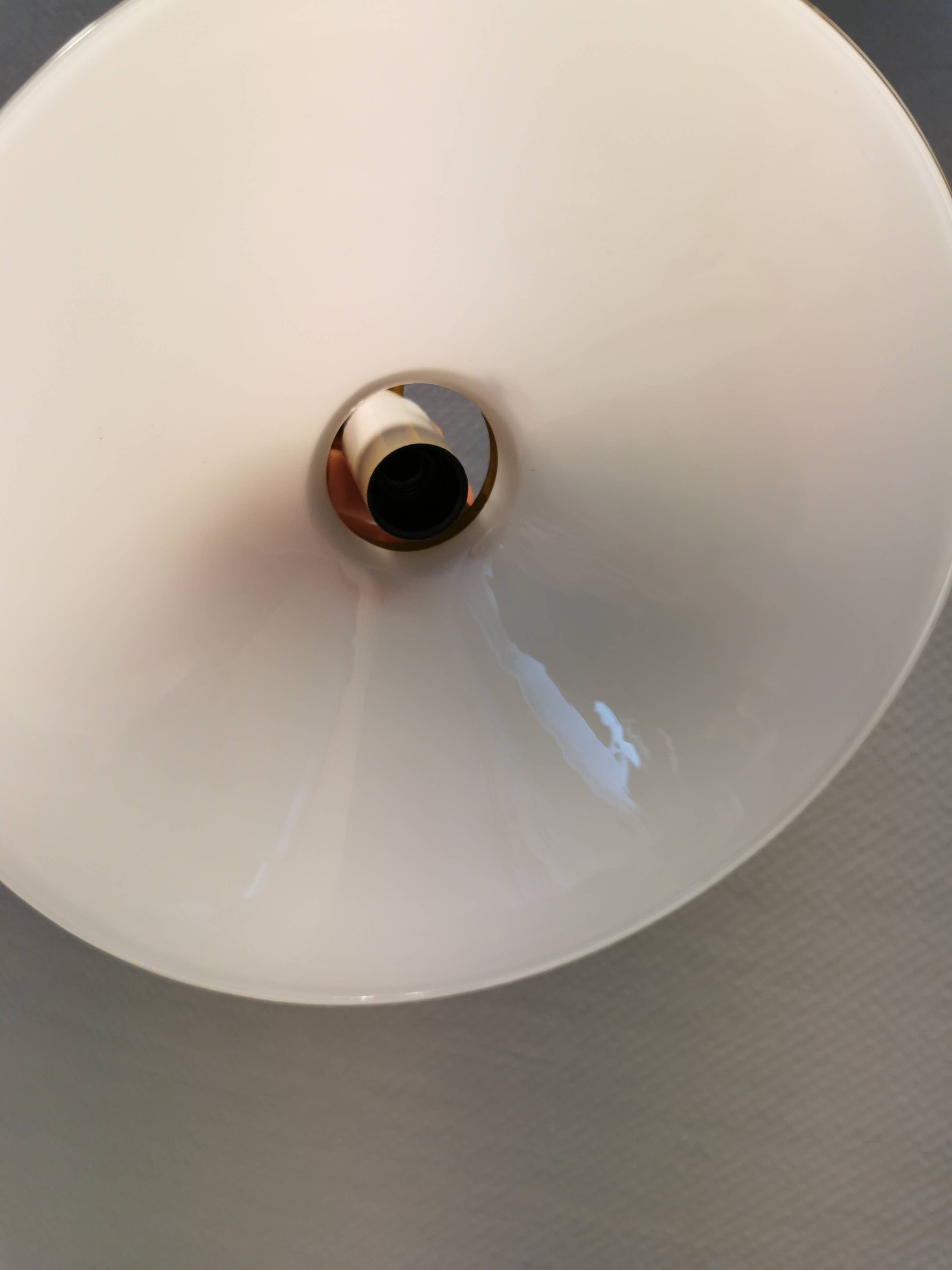 A set of hanging lamps in milky white opal glass with brass top.