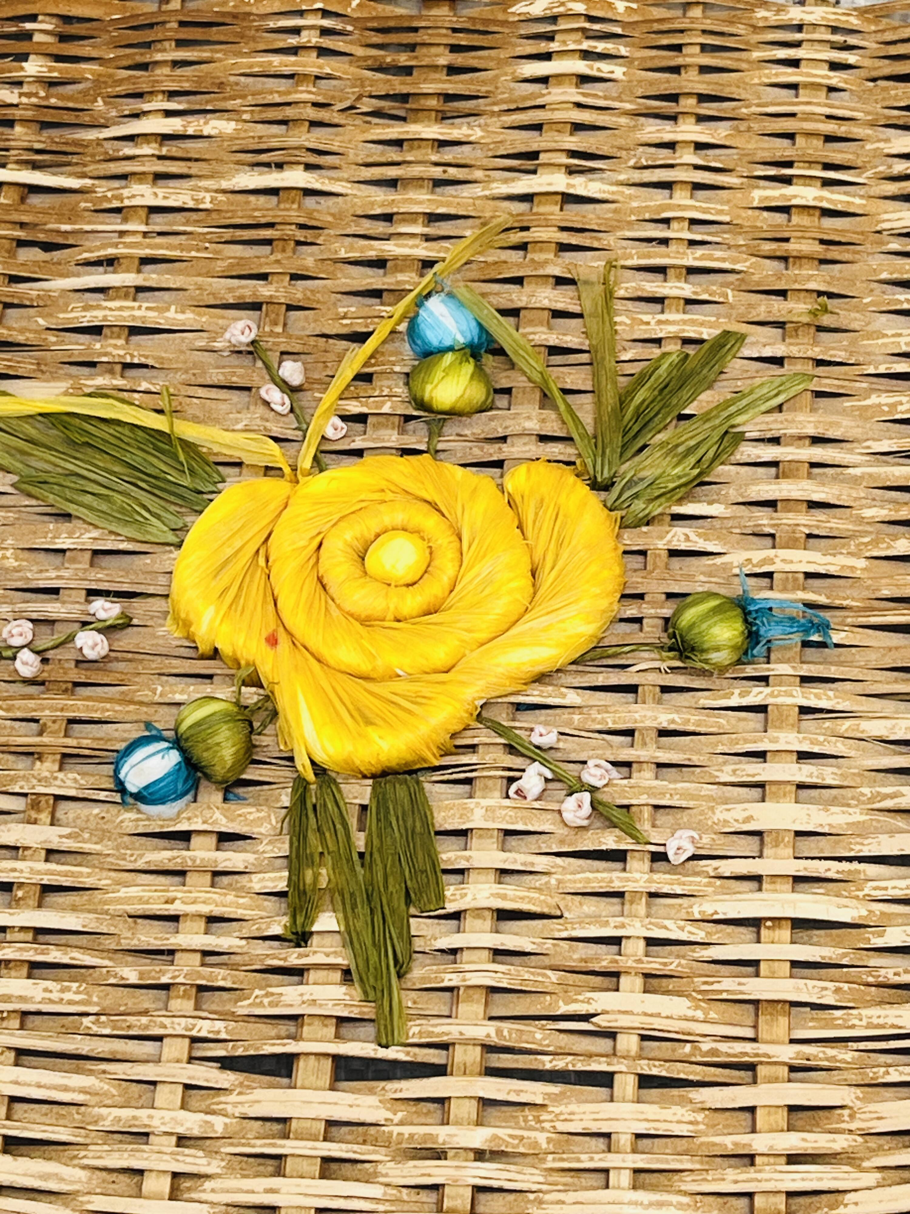 Vintage wicker mannequin with colourful floral decoration.