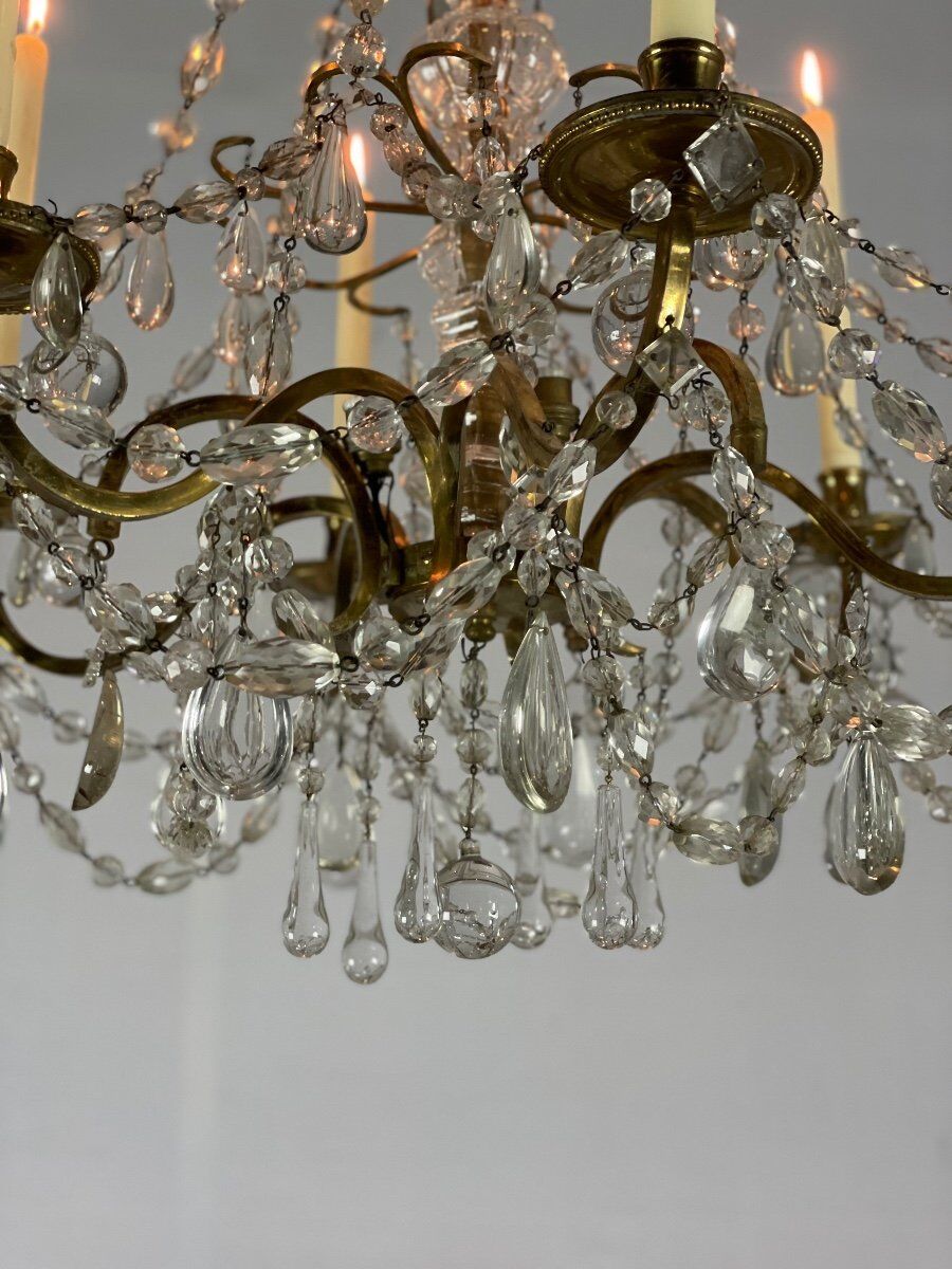 Golden bronze chandelier trimmed with drop-shaped grapevines