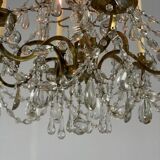 Golden bronze chandelier trimmed with drop-shaped grapevines