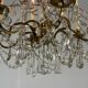 Golden bronze chandelier trimmed with drop-shaped grapevines