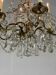 Golden bronze chandelier trimmed with drop-shaped grapevines