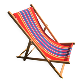 vintage wooden deck chair with red, blue, and yellow striped fabric