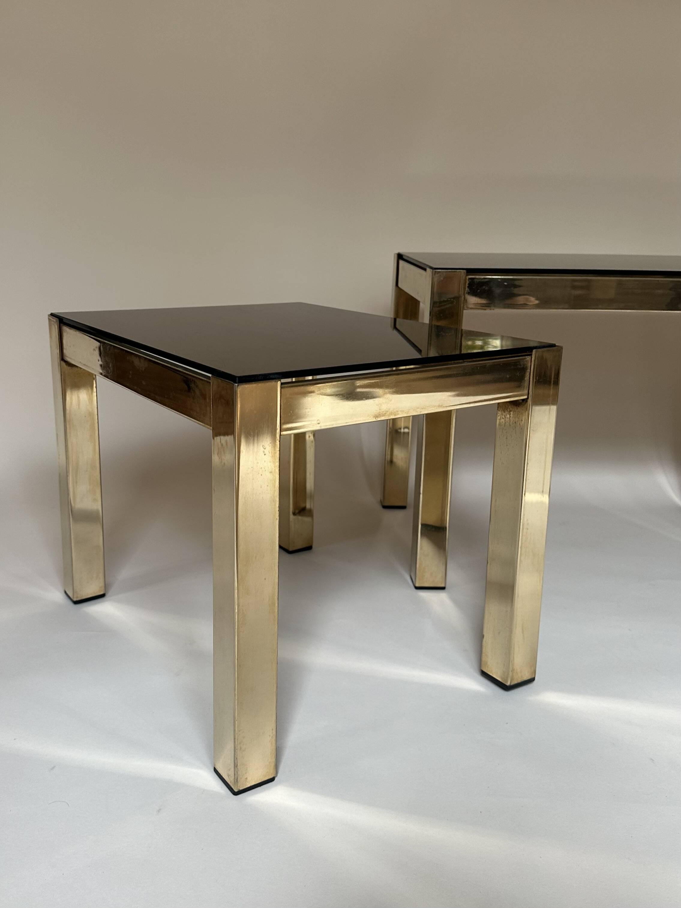 Set of three nesting side tables in brass and smoked mirror.