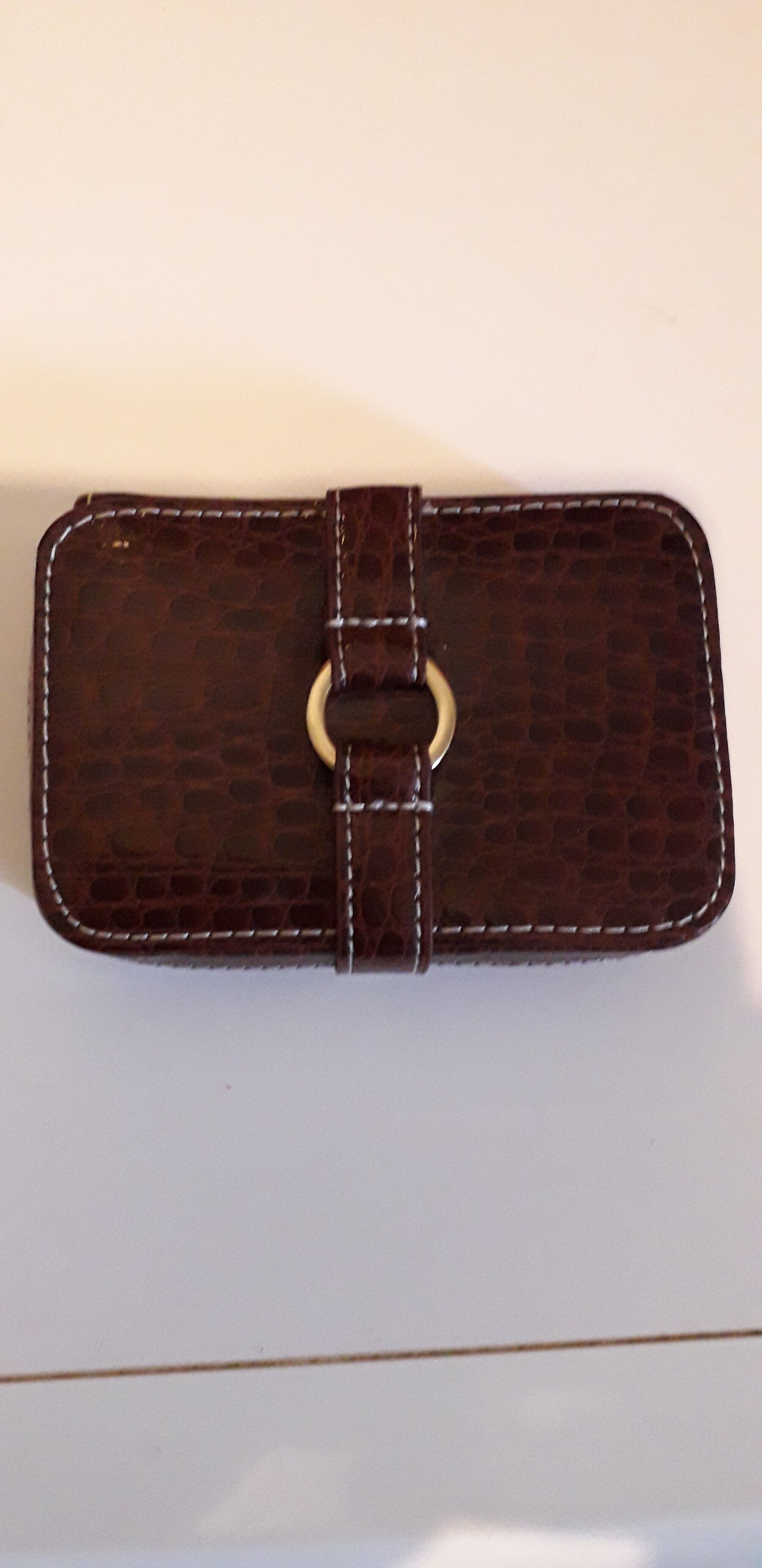 Small travel alarm clock in its case with jewelry compartments