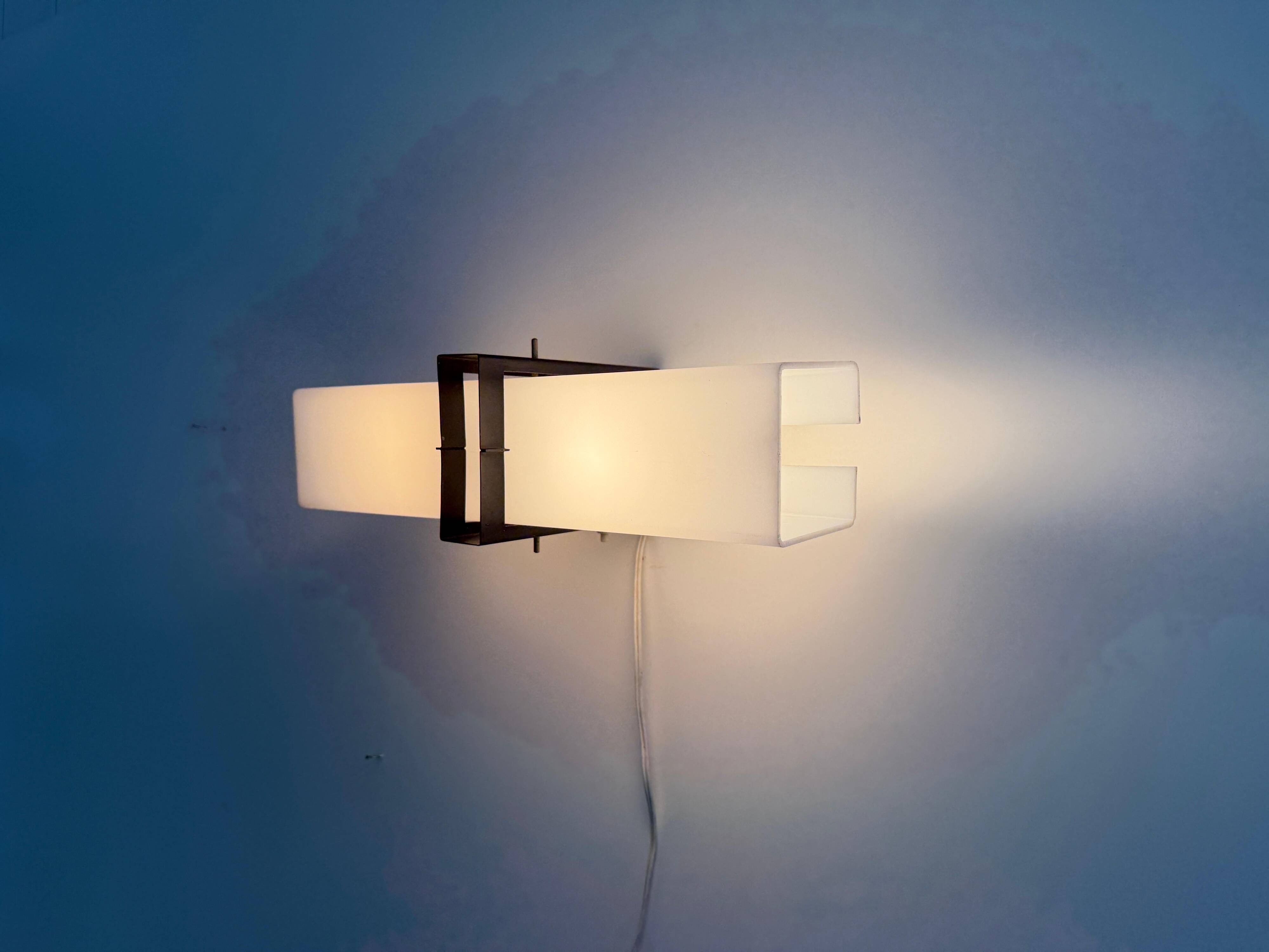 Simple white plexiglass wall light with a black metal frame, 1970s, Germany.