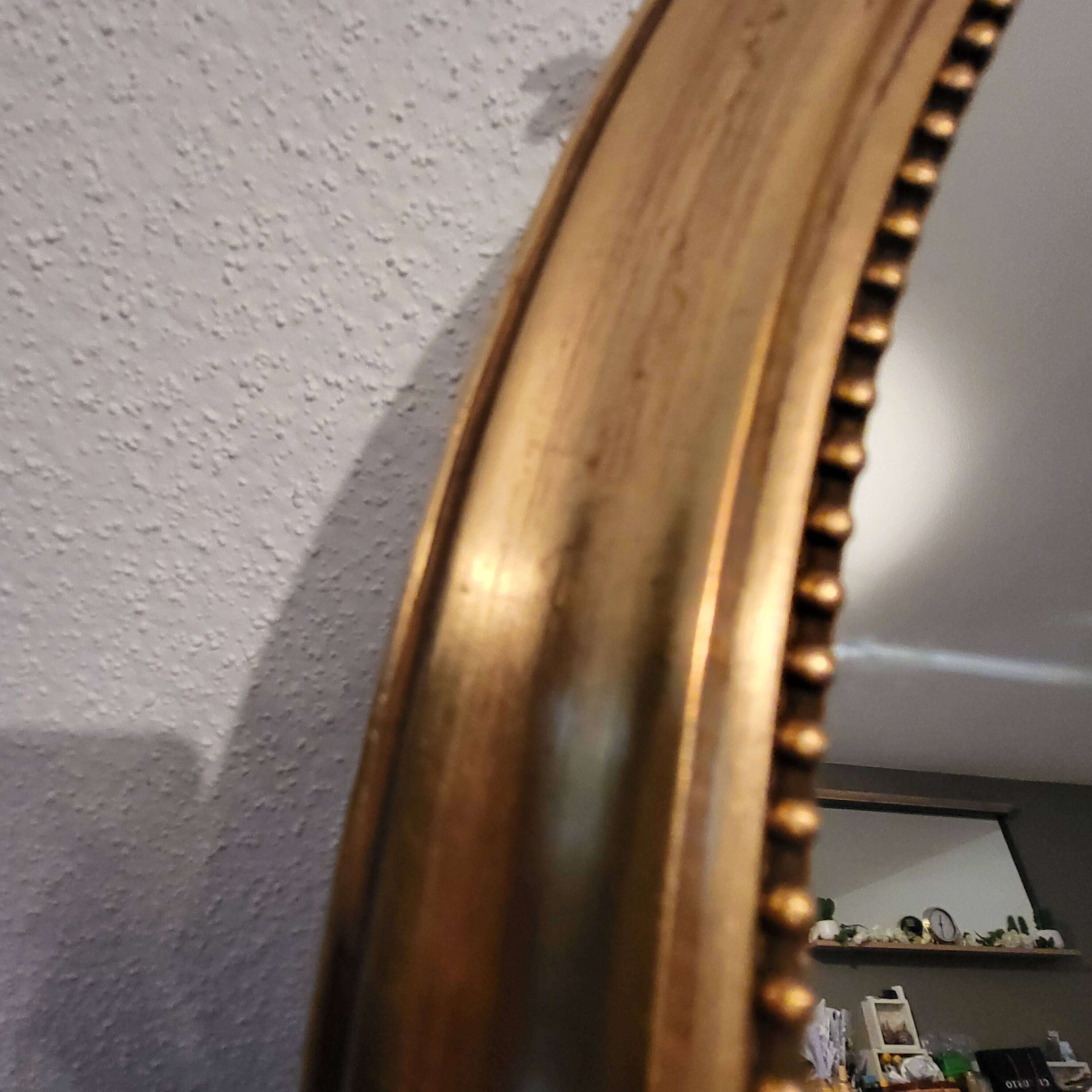Oval mirror with golden wooden knot