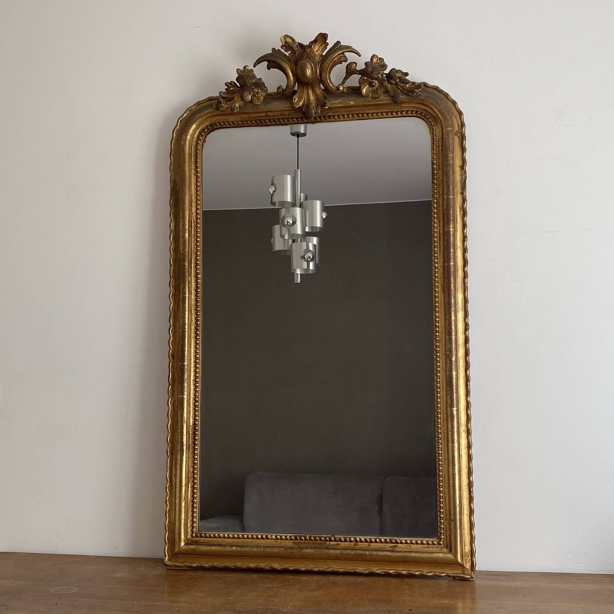 Golden mirror from the late 19th century with a decorated pediment. 130x74.