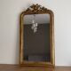Golden mirror from the late 19th century with a decorated pediment. 130x74.
