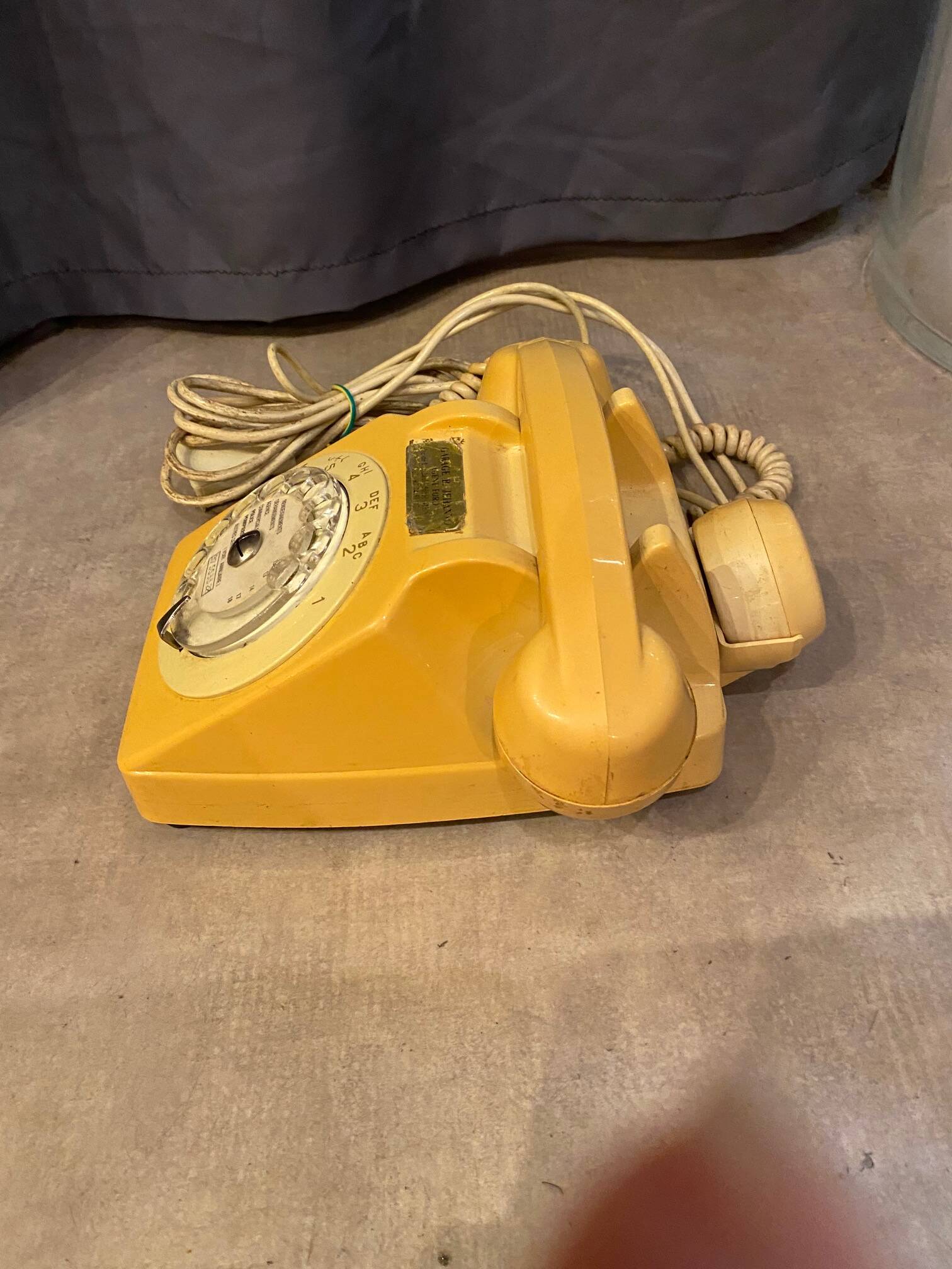 Old dial telephone from the 80s temat quimper bakelite yellow and beige