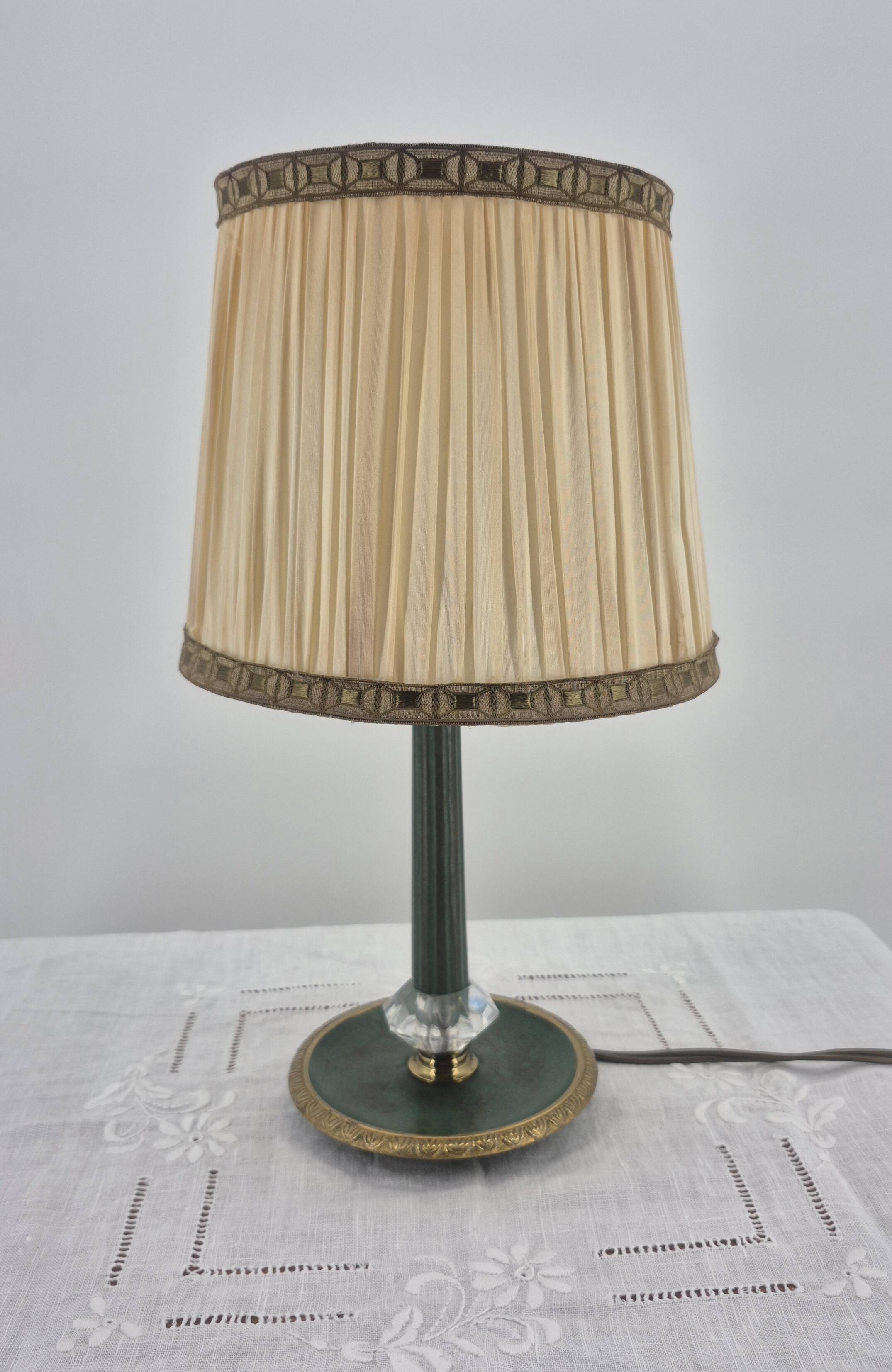 Brass table lamp with green patina and empire-style fabric shade.