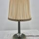 Brass table lamp with green patina and empire-style fabric shade.