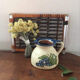 Terracotta jug with grape decoration.