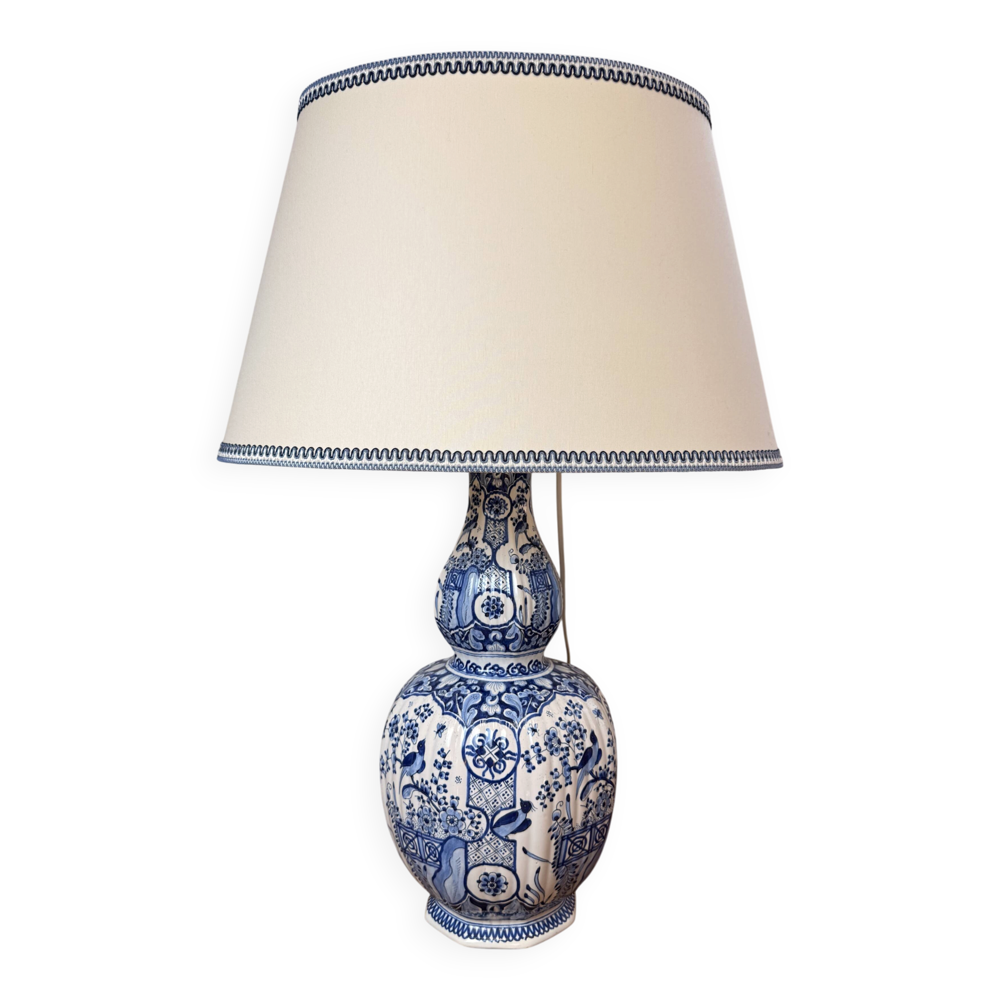 Blue and white Delft ceramic table lamp decorated with birds and flowers.