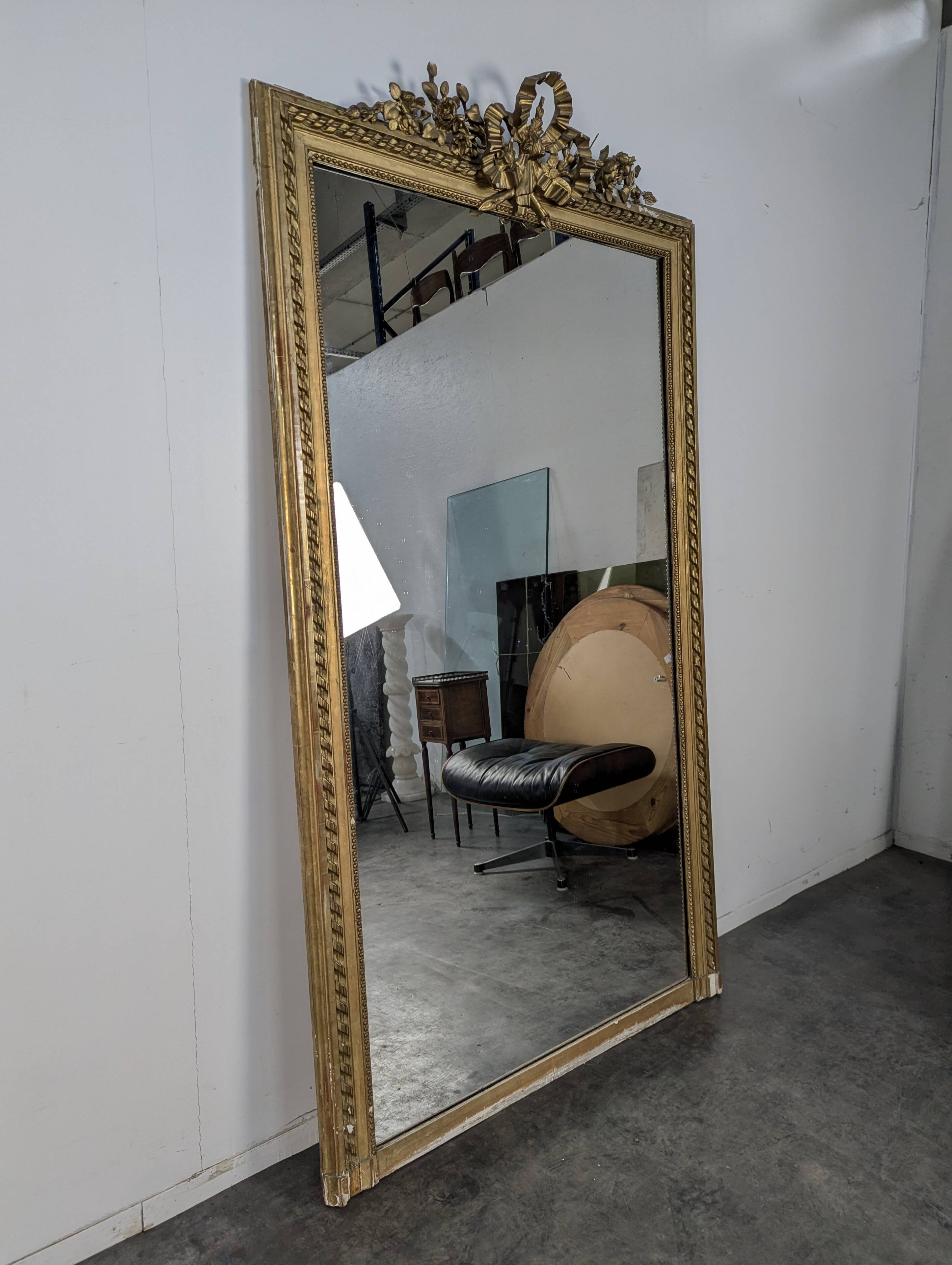 Golden Louis XVI style mirror with bouquet and shells.