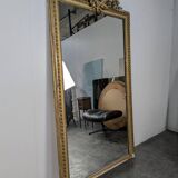 Golden Louis XVI style mirror with bouquet and shells.