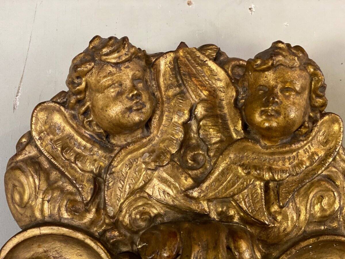 Paire d’appliques en bois sculpté et doré surmontées de deux têtes d’angelots, Italie