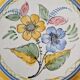 Large hand-painted French faience plate with floral decoration in folk art style.