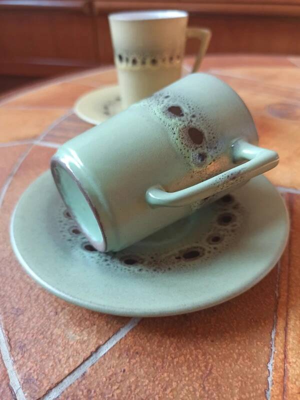 A pair of vintage glazed stoneware cups and saucers.