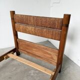 Brutalist style bed with chain and straw