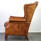 Positively lived-in sheepskin leather wing chair with pleasant seating comfort