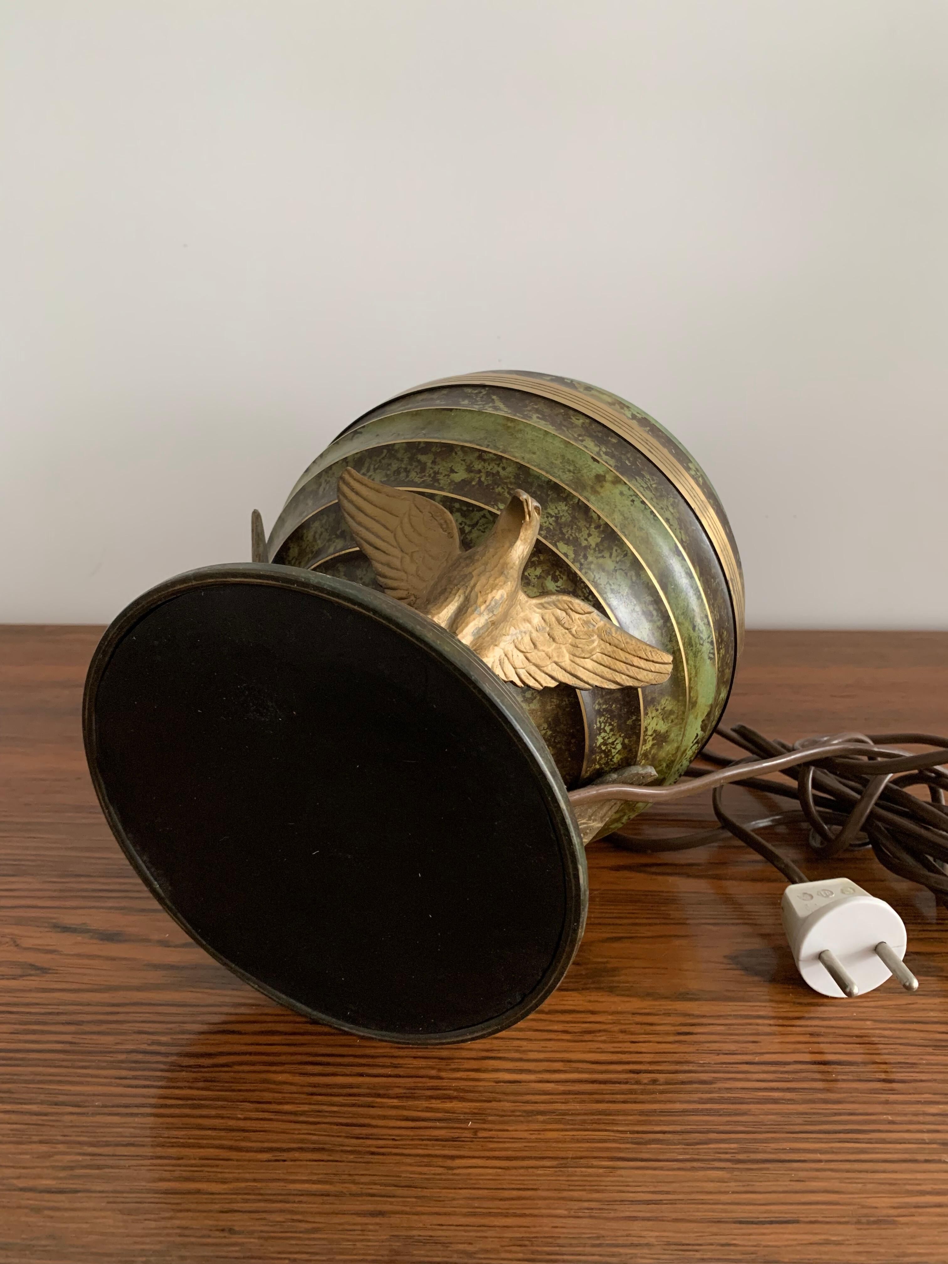 Art Deco table lamp in patinated bronze with eagles holding a globe, France 1940.