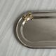 Small stainless steel tray with knot pattern.