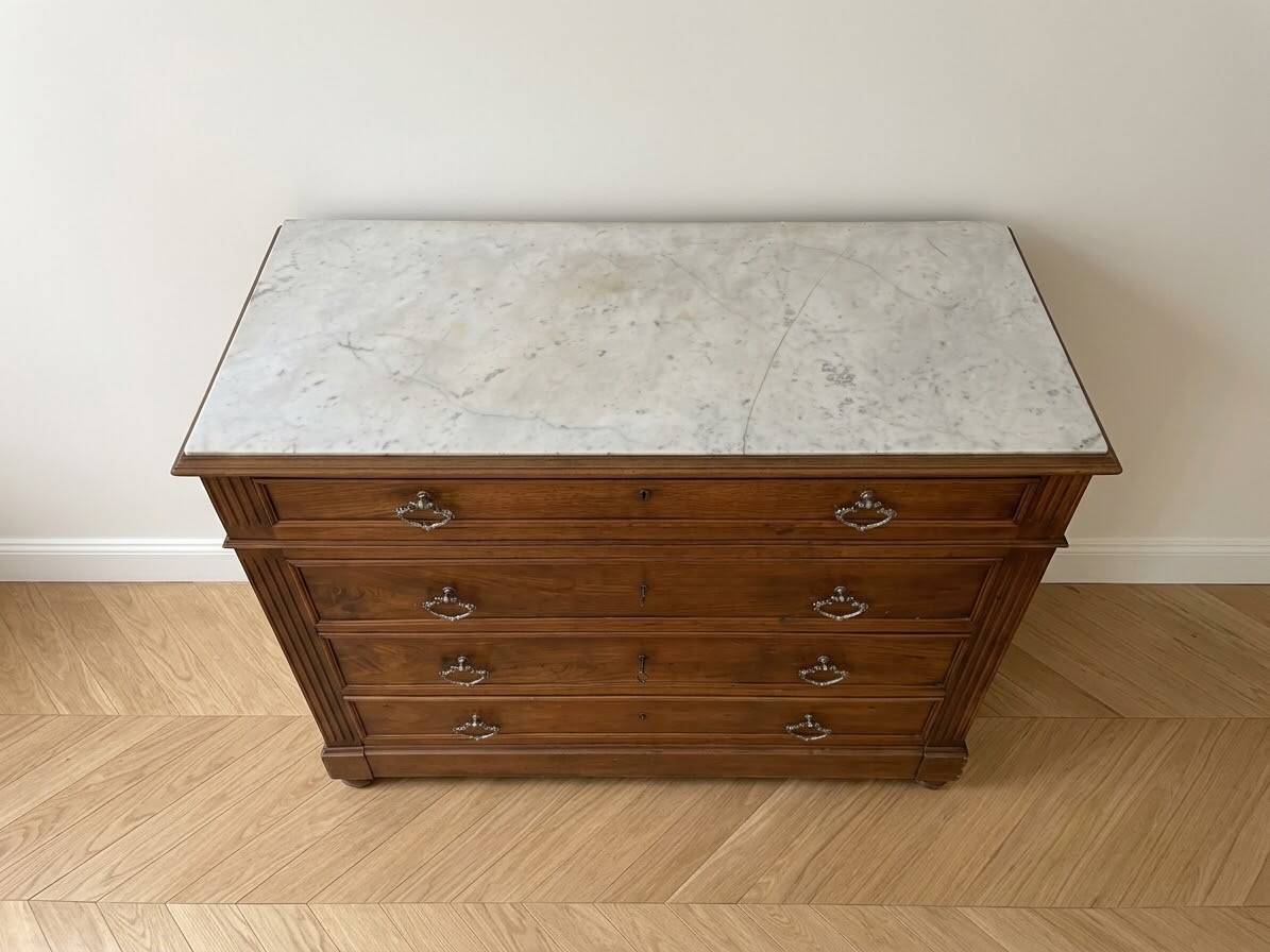 Antique wooden chest of drawers with a marble top.