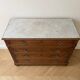 Antique wooden chest of drawers with a marble top.